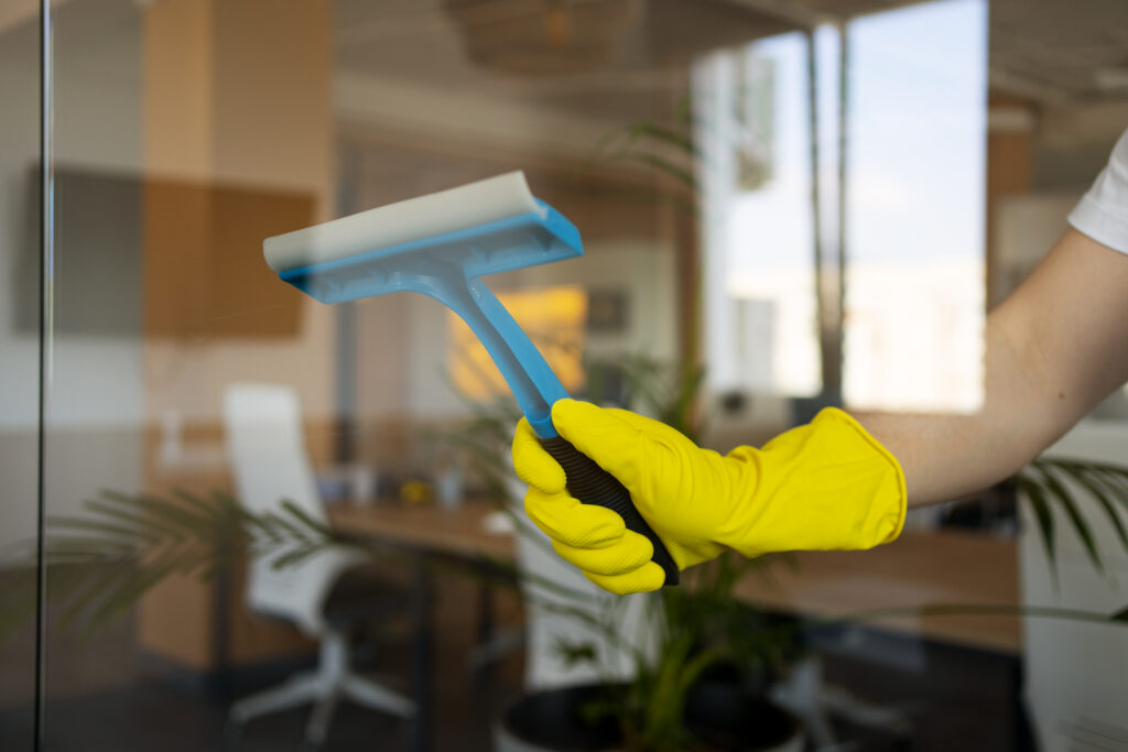 professional cleaning service person cleaning office window